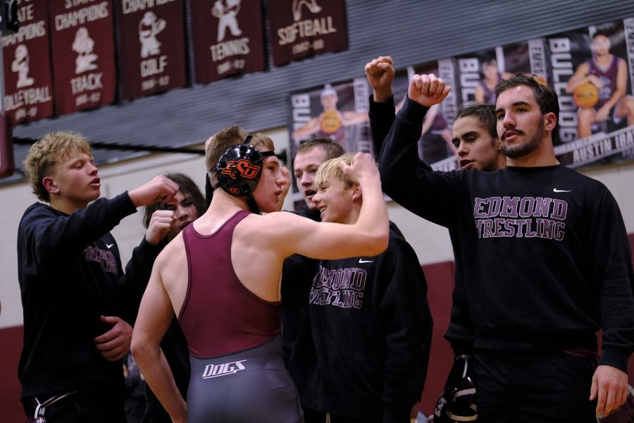Edmond teammates celebrate with a wrestler coming off the mat